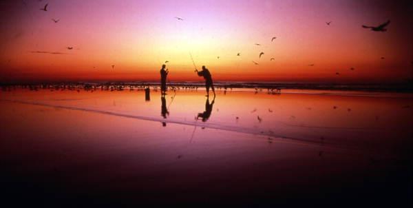 Pescador praticando surf fishing ao amanhecer em Daytona Beach