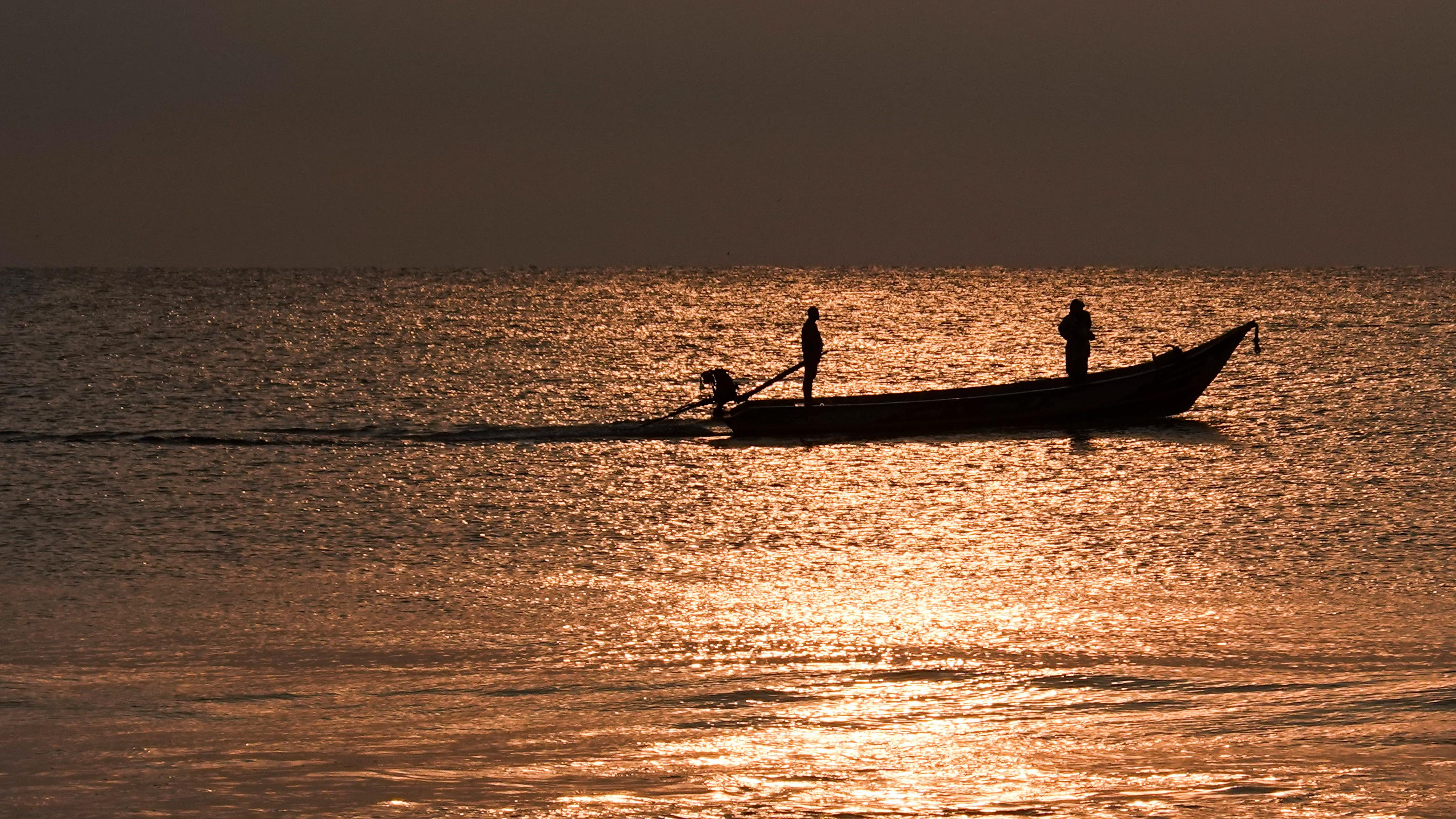 Barco de pesca costeira navegando ao amanhecer
