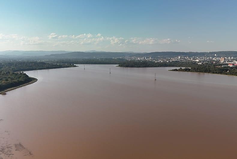 Lago com água turva visto da margem